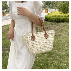 Detail of hand-woven straw tote bag with brown leather handles and mesh texture