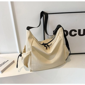 Minimalist beige canvas crossbody bag with black adjustable strap and side drawstring