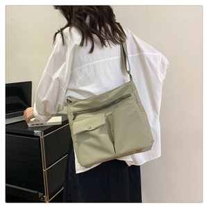 Dettaglio della borsa a tracolla in nylon impermeabile con design multitasche per pendolari