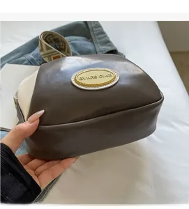 Detail der PU-Leder-Umhängetasche mit goldenem Metalllogo und gewebtem Jacquard-Gurt