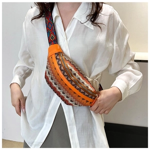 Close-up of bohemian orange jacquard waist bag with geometric embroidery on a white shirt