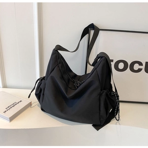 Minimalist black canvas shoulder bag with drawstring side and wide strap for daily commute