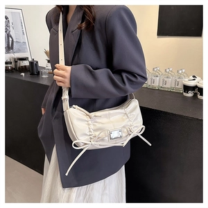 Détail du sac à bandoulière en PU crème avec plis élégants et ornements de nœuds