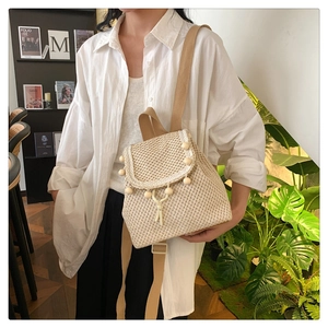 Detail of woven straw backpack with decorative wooden beads and drawstring closure