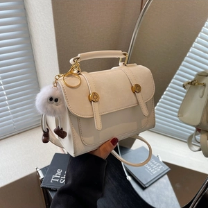 Minimalist beige PU leather flap handbag with gold buckle and plush monster charm