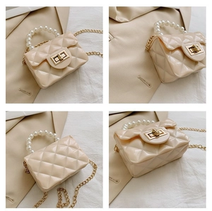 Détail du mini sac matelassé beige avec poignée en perles et chaîne dorée