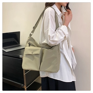 Dettaglio della borsa a tracolla beige in nylon con multitasche e ampia cinghia regolabile