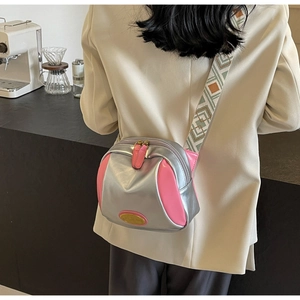 Detail der rosa-silbernen PU-Umhängetasche mit geometrisch gewebtem Schultergurt