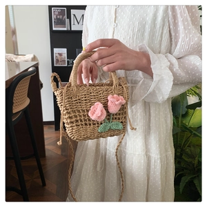 Close-up of handmade straw woven tote with 3D pink crochet tulip decorations