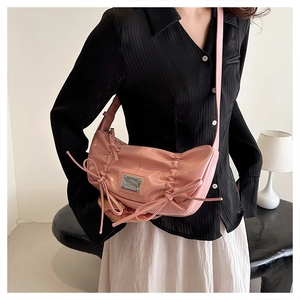 Sac à bandoulière en similicuir rose brillant avec nœuds latéraux et plaque logo argentée