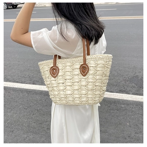 Macro detail of straw woven tote bag with beige fiber texture and brown leather handle