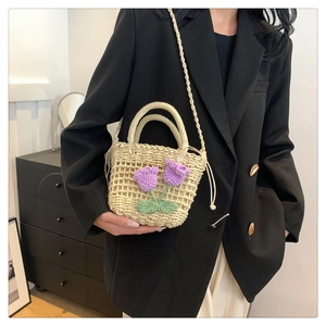 Detailed straw bucket bag with purple crochet tulip flowers and woven mesh texture