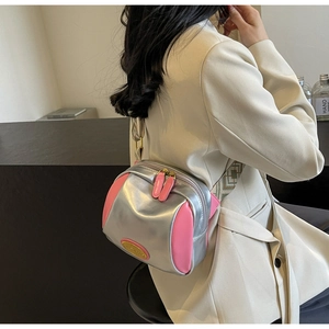 Detail der silbernen Metallic-Umhängetasche mit rosa Seitenteilen und Jacquard-Riemen
