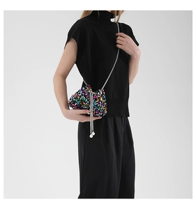 Close-up of rainbow sequin mini bucket bag with silver chain strap and pearl details