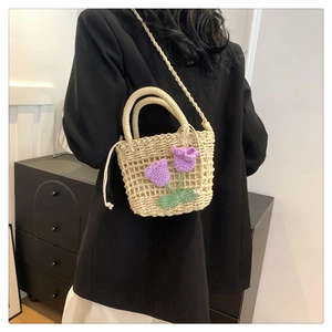 Detail of hand-woven straw bag featuring purple crochet tulips and a drawstring liner