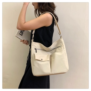 Dettaglio della borsa tote in tessuto Oxford crema con design funzionale multitasche