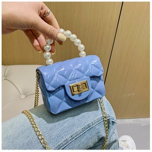 Détail du mini sac jelly bleu matelassé avec poignée perle et chaîne dorée