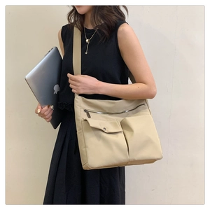 Vista dettagliata della borsa a tracolla kaki con design multitasche e trama in nylon