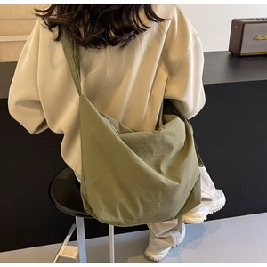 Minimalist olive green canvas crossbody bag shown on a model for casual daily styling