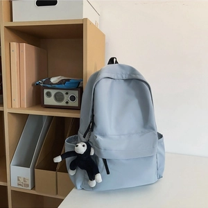 Fashionable nylon backpack for women in light blue-grey with a plush monkey charm
