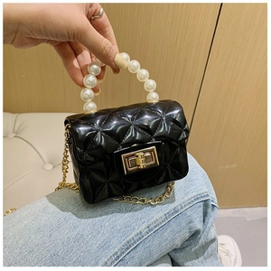 Détail du mini sac noir avec poignée en perles et bandoulière en chaîne dorée
