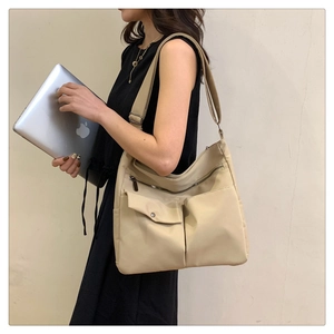 Dettaglio borsa beige in nylon con tasche multiple e tracolla regolabile per pendolari