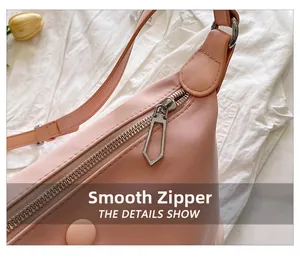 Detailed close-up of smooth silver zipper on a pink fabric fashion shoulder bag