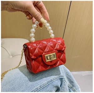 Détail du mini sac matelassé rouge avec poignée en perles et fermoir rotatif doré