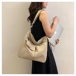 Dettaglio borsa a tracolla in nylon beige con tasche multiple e ampia cinghia