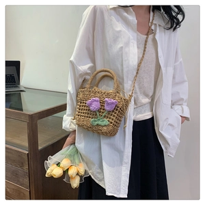Detail of hand-woven straw bag with purple floral crochet pattern and drawstring closure