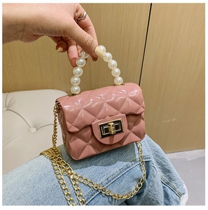 Détail du mini sac rose matelassé avec poignée en perles et chaîne dorée