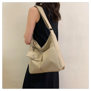 Dettaglio della borsa a tracolla beige in tessuto Oxford con tasche a cerniera