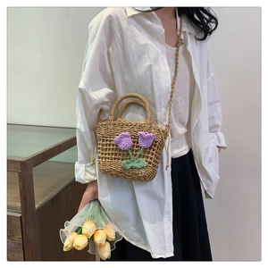 Detail of handwoven straw bag featuring 3D knitted purple tulip floral decorations