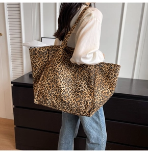 Detalle del bolso tote grande de lona con estampado de leopardo y remaches de refuerzo