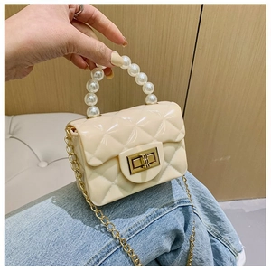 Détail du mini sac matelassé blanc crème avec poignée en perles et chaîne dorée