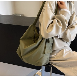Macro shot of large olive green hobo bag showing durable matte fabric and side pocket