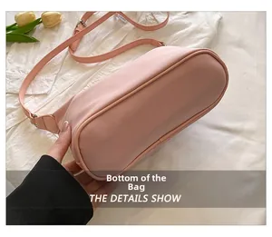 Detailed view of the rounded bottom and fine stitching of this pink nylon handbag