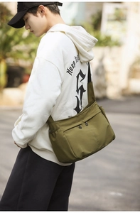 Side view of olive green canvas messenger bag with adjustable black shoulder strap