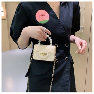 Détail du mini sac gelée crème avec motif matelassé et poignée en perles nacrées