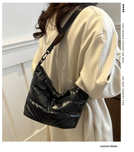 Detail of glossy black quilted shoulder bag featuring premium high-shine nylon fabric