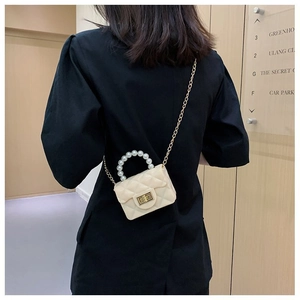 Détail du mini sac gelée crème avec poignée en perles et chaîne dorée sur mannequin