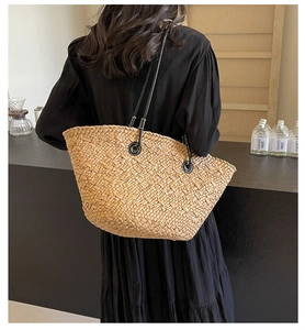 Vue détaillée d'un grand sac cabas en paille avec bandoulières en cuir noir au café