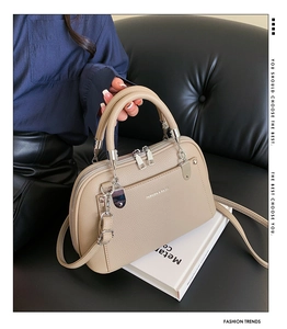 Détail du sac à main en cuir grainé kaki avec ferrures argentées et texte de mode