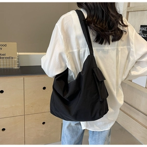Macro shot showing the durable nylon texture and side pocket detail of this black tote bag