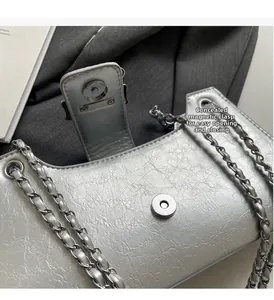 Dettaglio della borsa in pelle argentata con chiusura magnetica invisibile e trama
