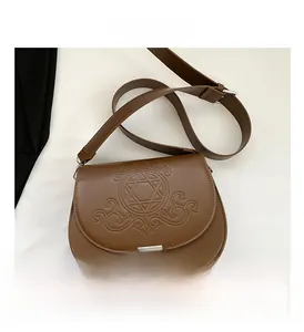 Vue détaillée du sac besace marron avec gaufrage en étoile et fermoir métallique argenté