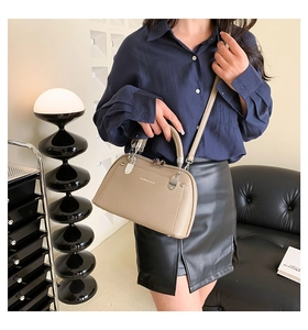 Détail du sac bandoulière beige élégant avec texture litchi et finitions métalliques argent