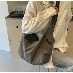 Close-up of minimalist nylon crossbody bag with side flap pocket and wide strap details