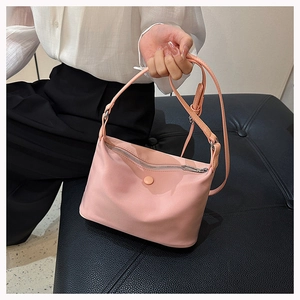 Detail of pink nylon crossbody bag featuring silver zipper and adjustable shoulder strap
