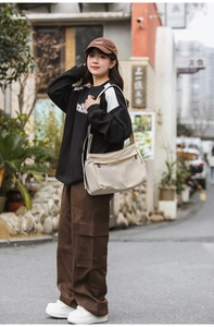 Close-up of minimalist beige nylon crossbody bag featuring adjustable fabric shoulder strap